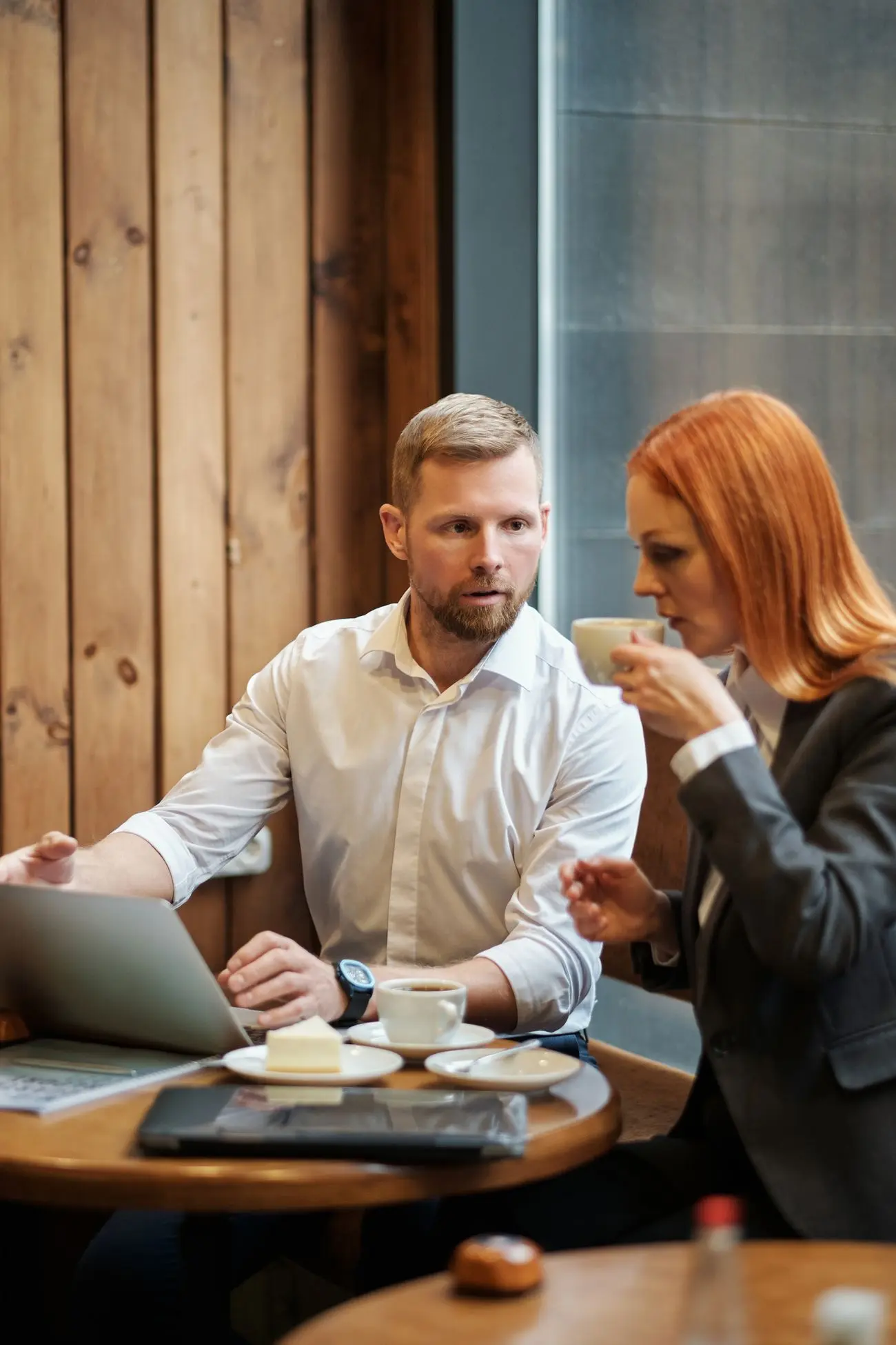 Two colleagues talking through a project at a small table