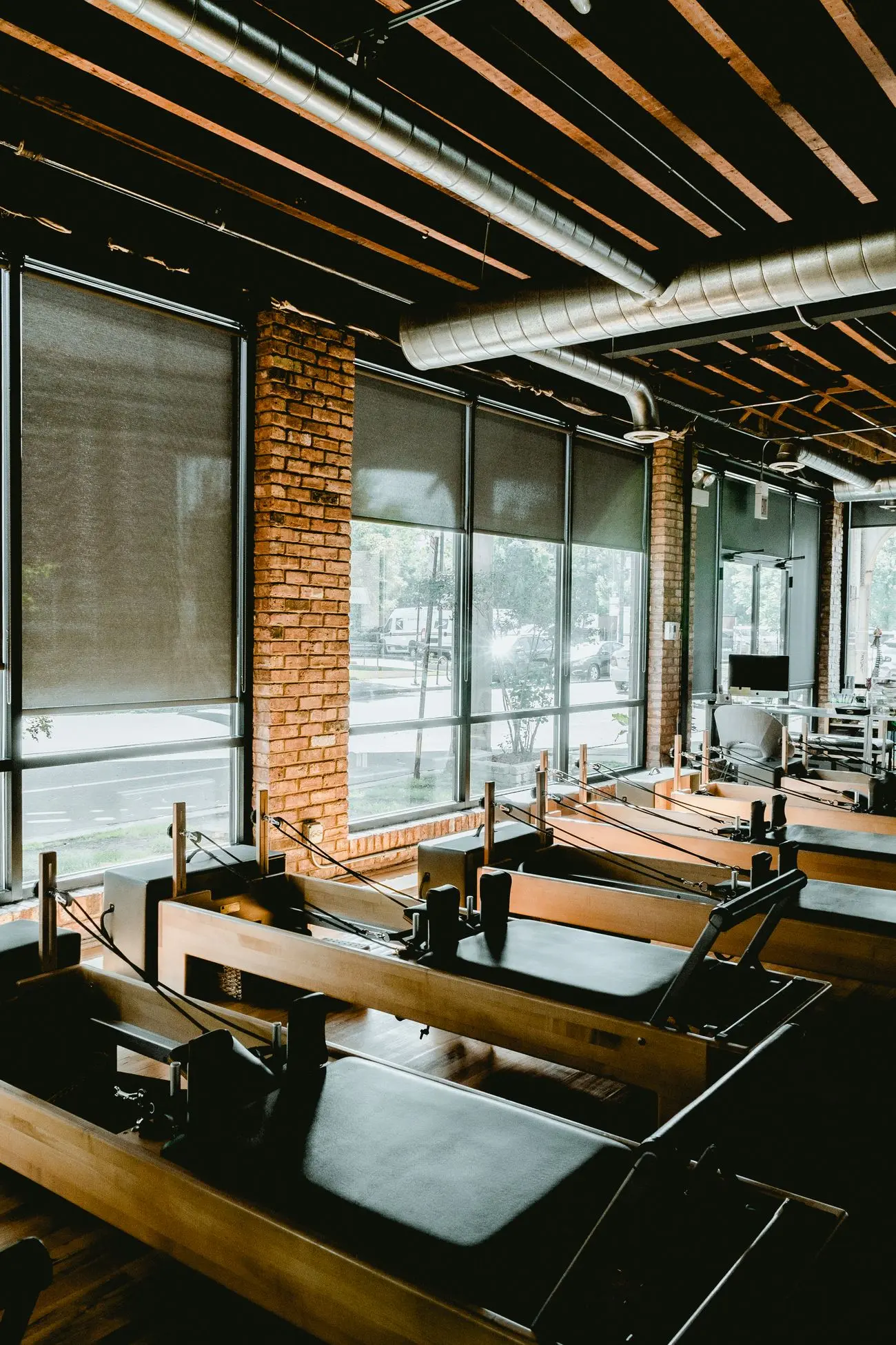 A fitted-out pilates studio with reformers by tall windows