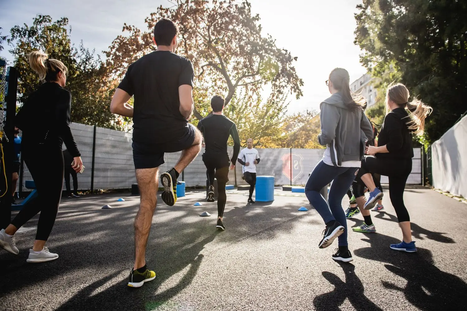 A group warming up together outdoors in low sunlight
